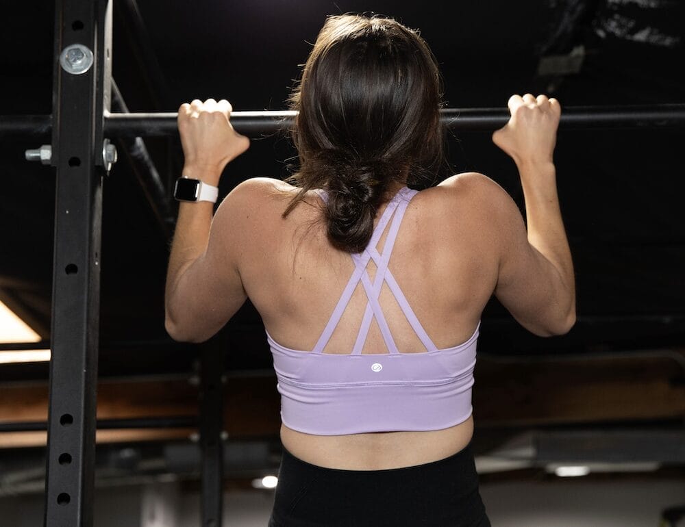 woman lifting weights in a bright gym, representing creatine benefits for women