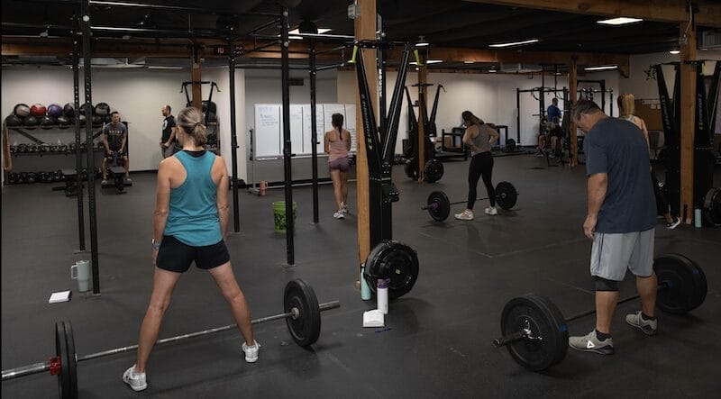 Tucson personal training clients lifting weights with coach guidance for safe, effective strength training.
